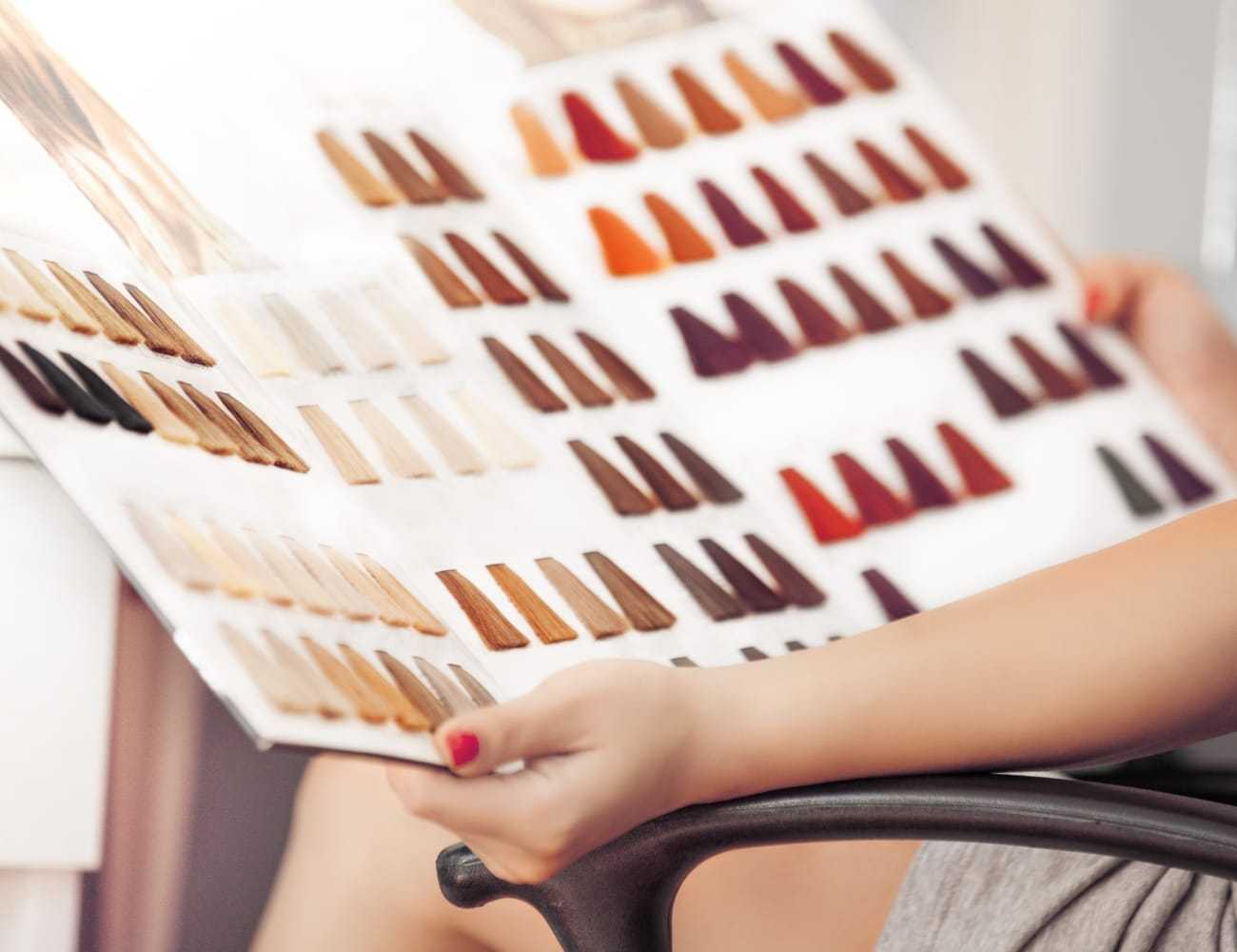 Color chart with various hair dye samples in a salon setting.